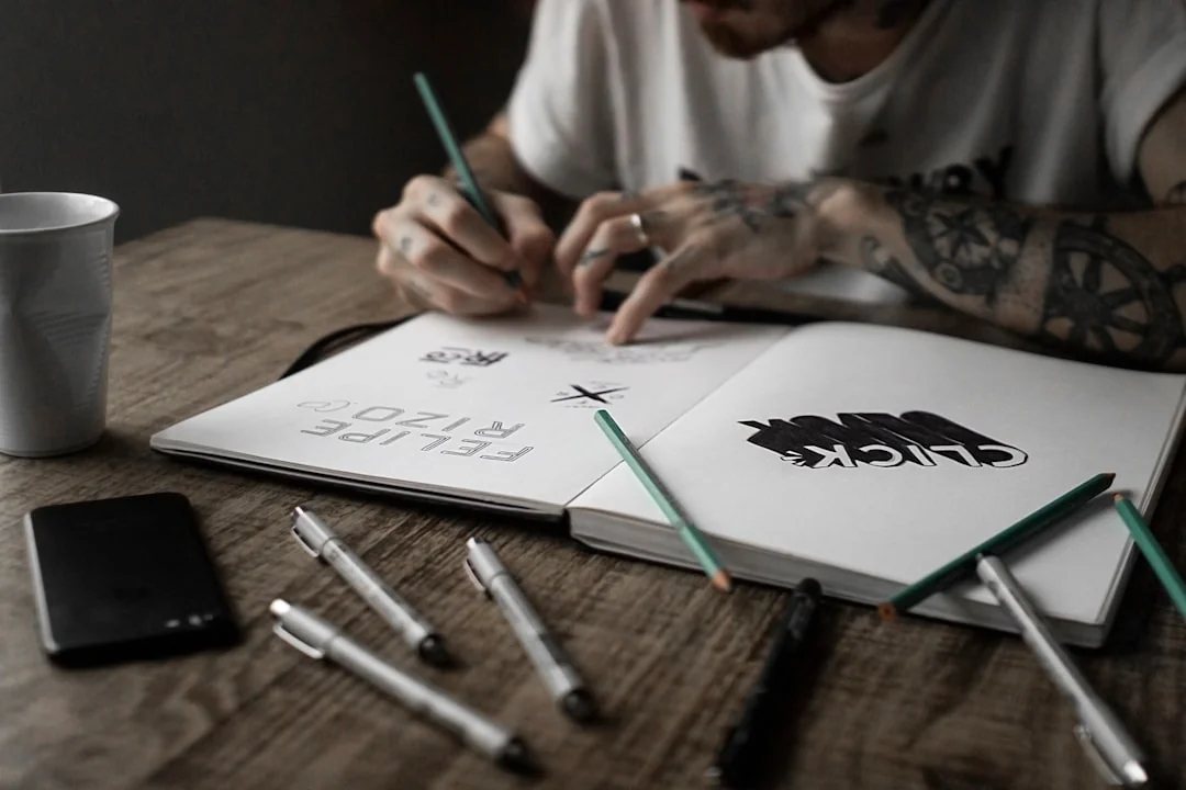 Une vue plongeante sur un espace de travail minimaliste avec un ordinateur portable et une feuille blanche posés sur une table en bois.